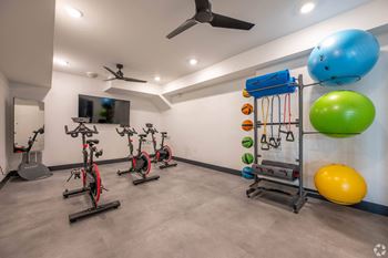 a gym with a bunch of exercise equipment and a blue ball